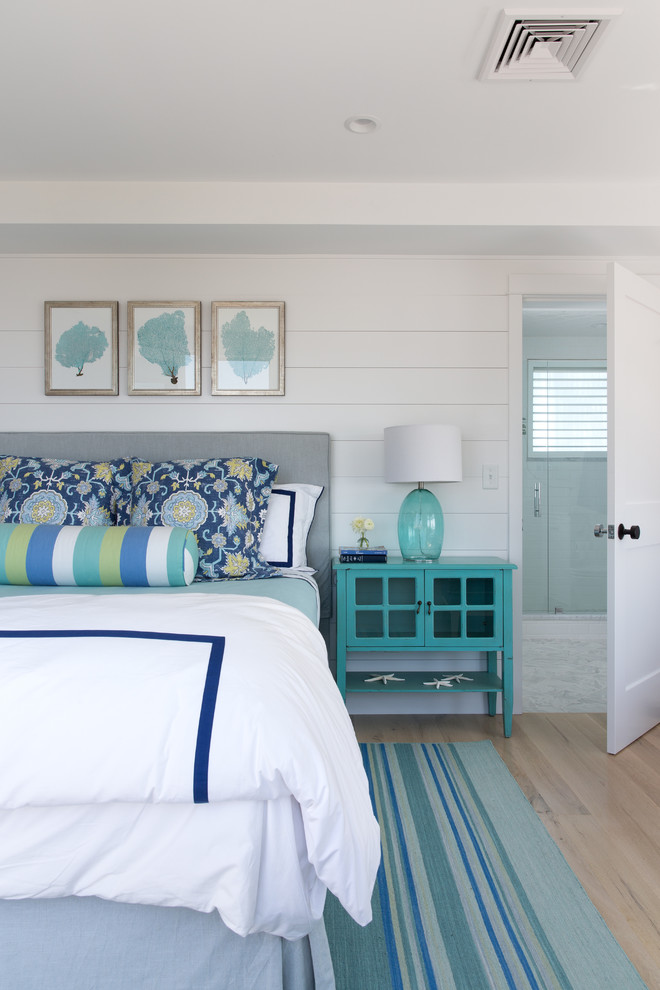 Imagen de dormitorio principal costero grande con paredes blancas y suelo de madera clara