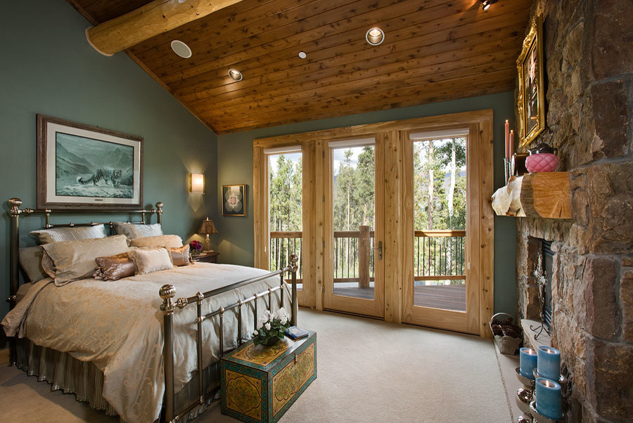 На фото: гостевая спальня среднего размера, (комната для гостей) в стиле рустика с серыми стенами, ковровым покрытием, горизонтальным камином, фасадом камина из камня и бежевым полом с
