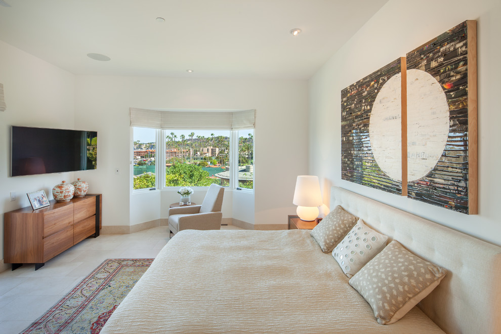 This is an example of a mediterranean bedroom in San Diego with white walls and beige floors.