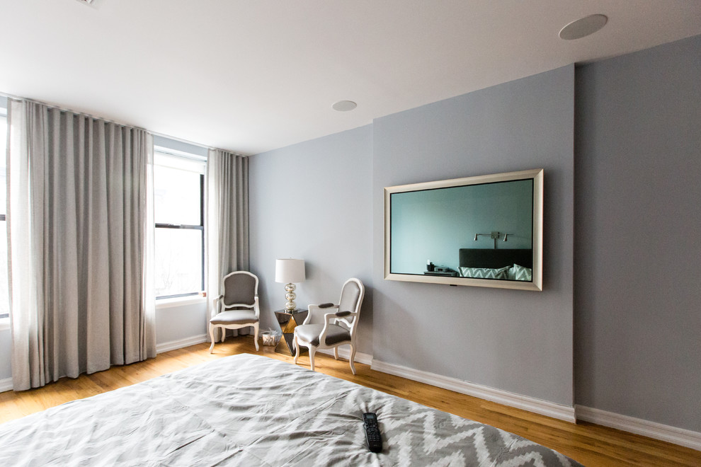 Immagine di una camera da letto minimalista con pareti grigie e parquet chiaro