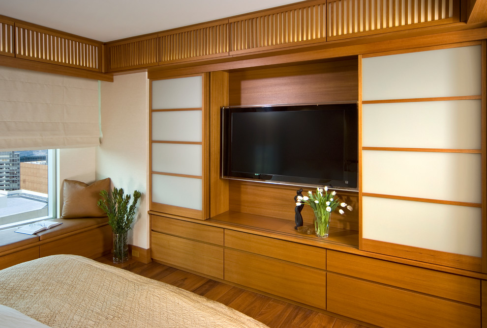 Ejemplo de dormitorio principal minimalista de tamaño medio con paredes beige y suelo de madera en tonos medios