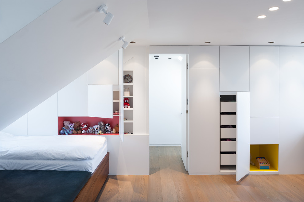 Small contemporary bedroom in London with white walls, light hardwood flooring and no fireplace.