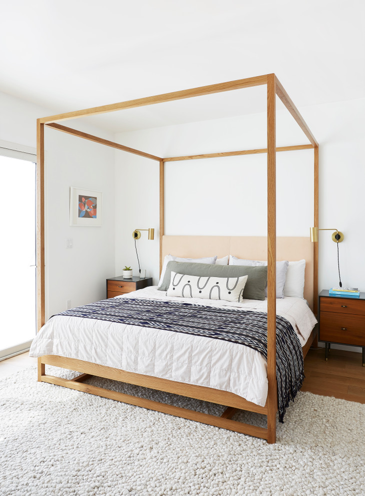 Ispirazione per una camera da letto contemporanea con pareti bianche, pavimento in legno massello medio e pavimento marrone