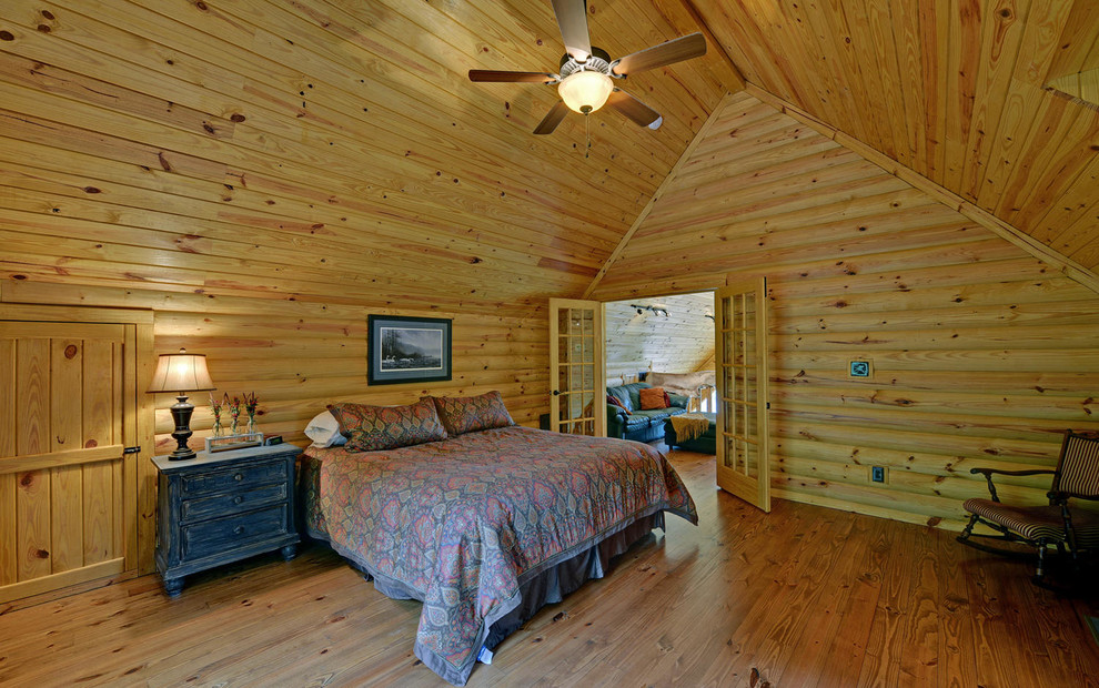 Diseño de dormitorio tipo loft rural grande con paredes marrones, suelo de madera en tonos medios y suelo marrón