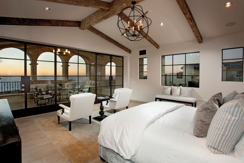 Idee per una camera da letto mediterranea con pareti beige e pavimento in legno massello medio
