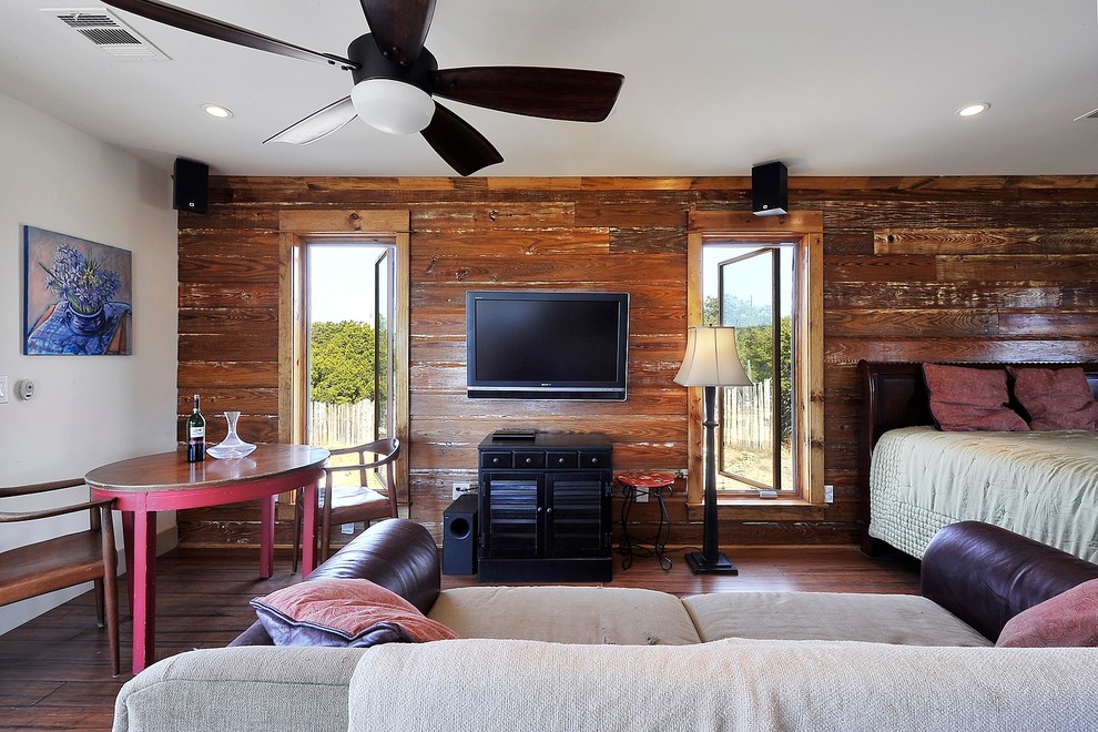 Photo of a rustic guest bedroom in Austin with white walls, dark hardwood flooring and no fireplace.