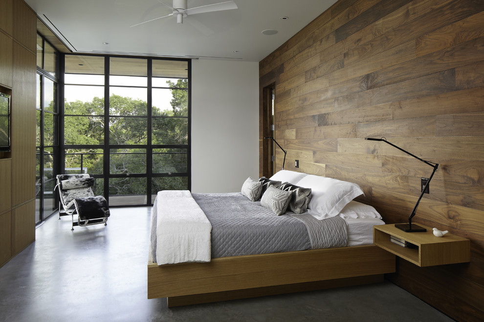 Example of a minimalist concrete floor and gray floor bedroom design in Austin