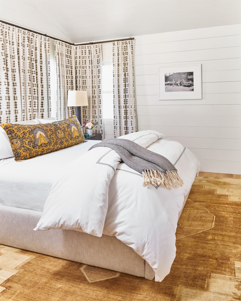 Immagine di una camera degli ospiti country di medie dimensioni con pareti bianche, parquet chiaro e pavimento marrone