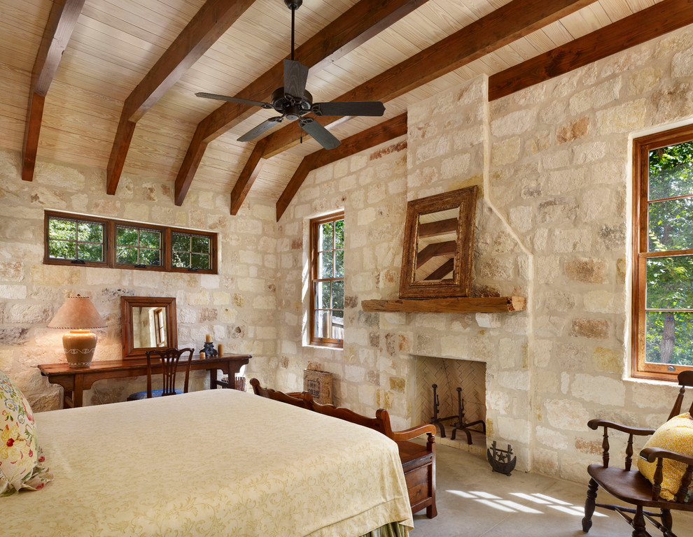 Example of a mountain style bedroom design in Houston with a stone fireplace
