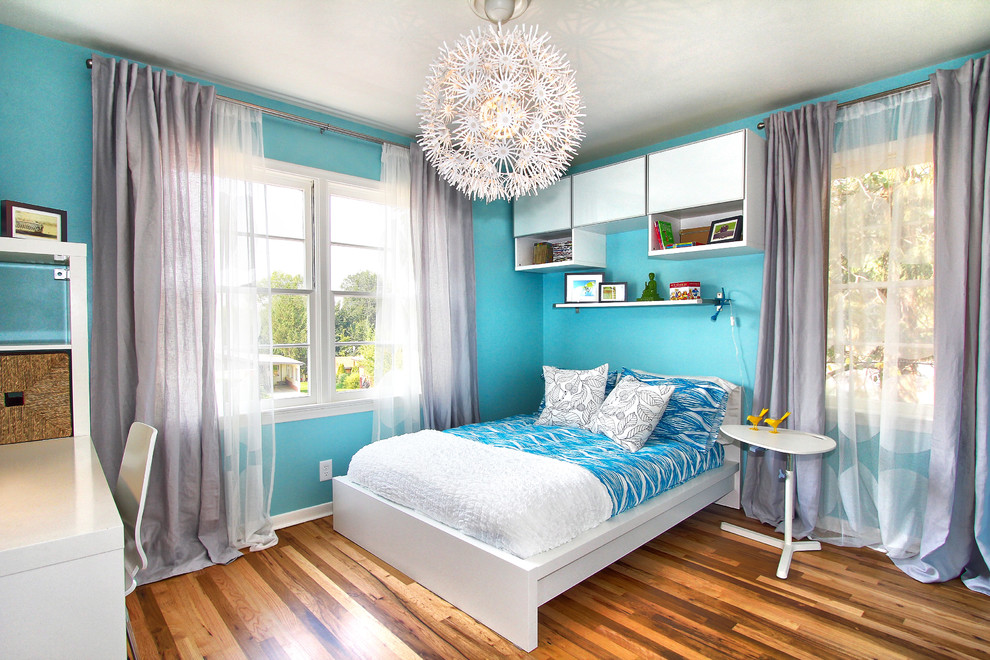 Esempio di una piccola camera degli ospiti moderna con pareti blu e pavimento in legno massello medio