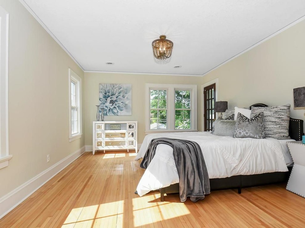 Inspiration pour une chambre traditionnelle avec un mur beige, un sol en bois brun et un sol multicolore.