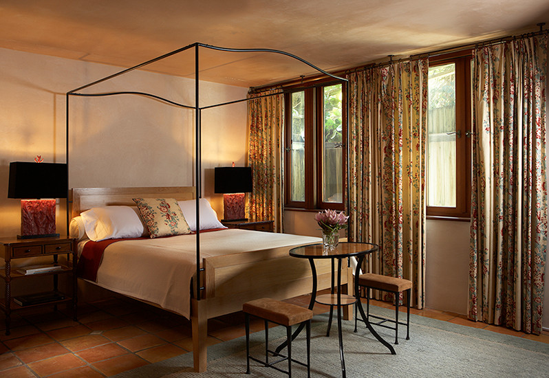 Modelo de habitación de invitados moderna de tamaño medio sin chimenea con paredes beige y suelo de baldosas de terracota