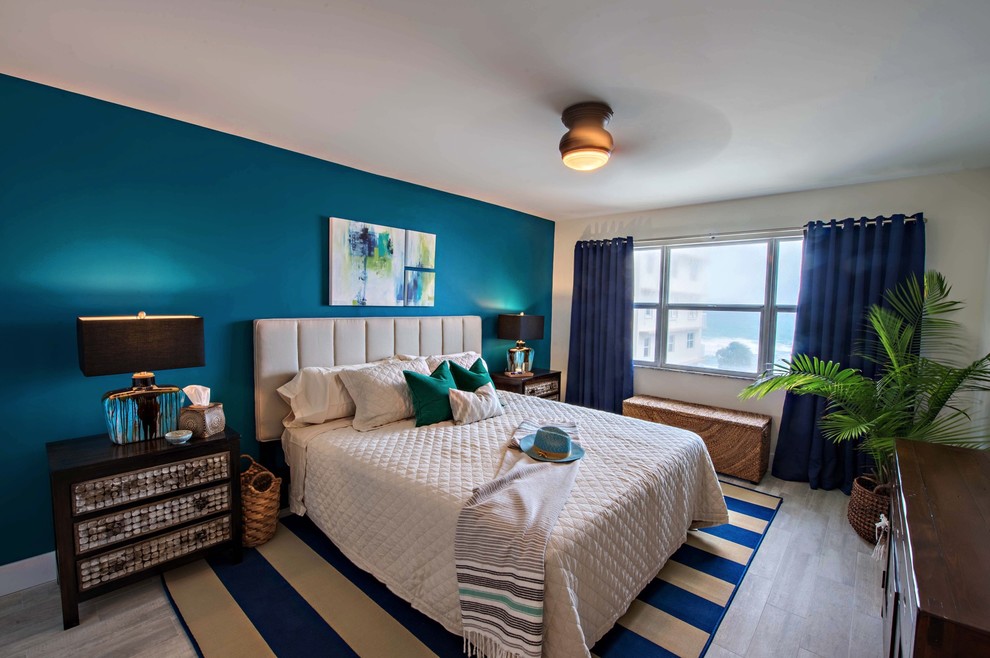 Photo of a medium sized coastal master bedroom in Miami with blue walls, porcelain flooring, grey floors and feature lighting.