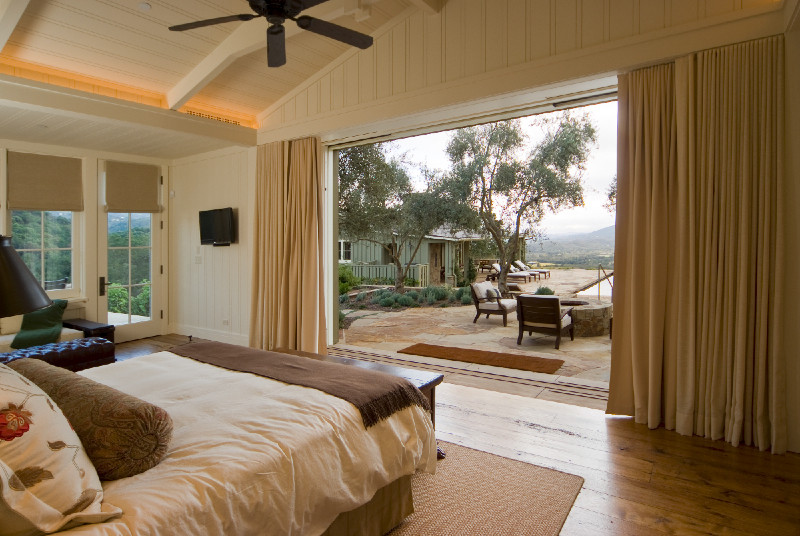 Diseño de habitación de invitados campestre grande sin chimenea con paredes blancas y suelo de madera en tonos medios