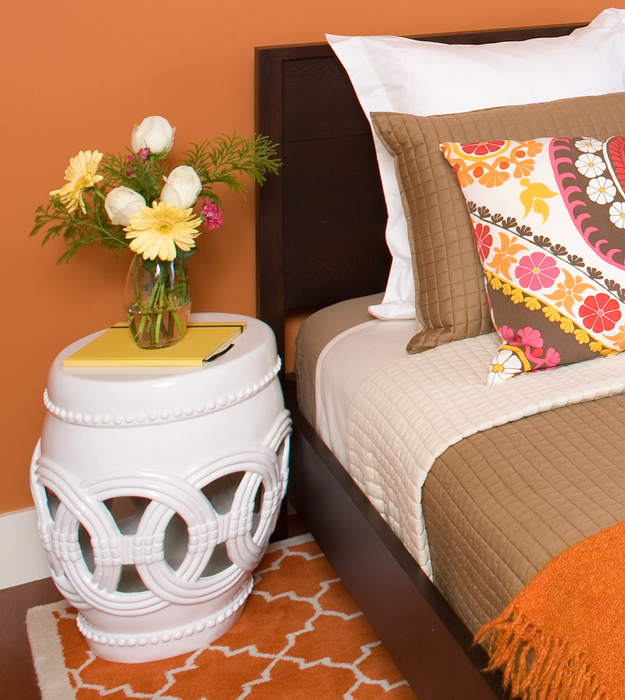 Exemple d'une chambre parentale tendance de taille moyenne avec un sol en bois brun, un mur orange et aucune cheminée.