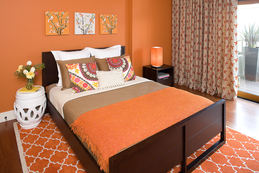 Inspiration for a mid-sized eclectic guest orange floor and medium tone wood floor bedroom remodel in San Francisco with orange walls and no fireplace