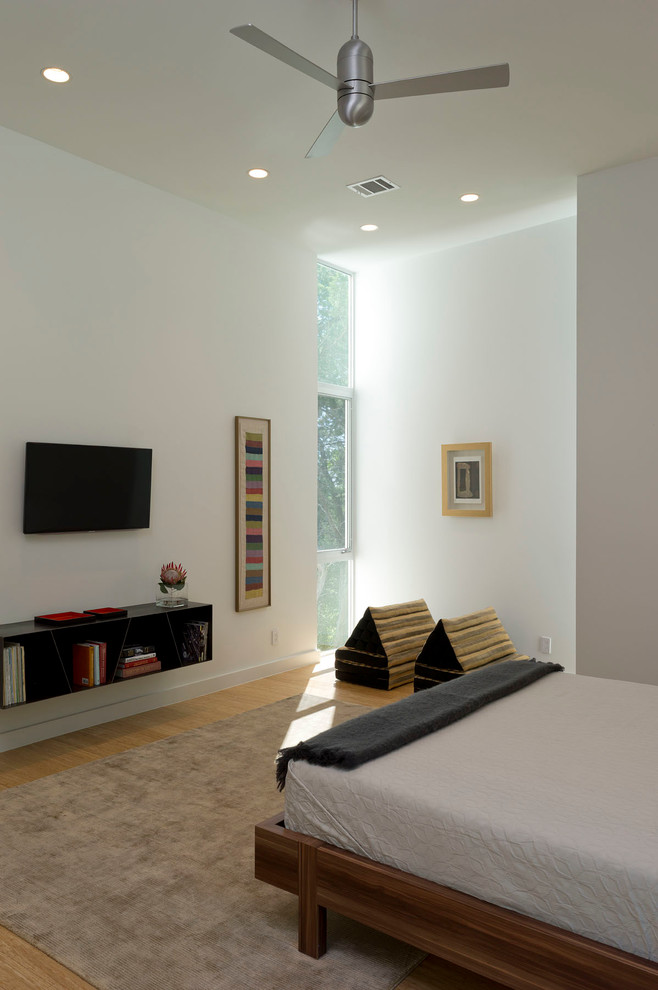 На фото: хозяйская спальня среднего размера в современном стиле с белыми стенами, светлым паркетным полом и коричневым полом без камина