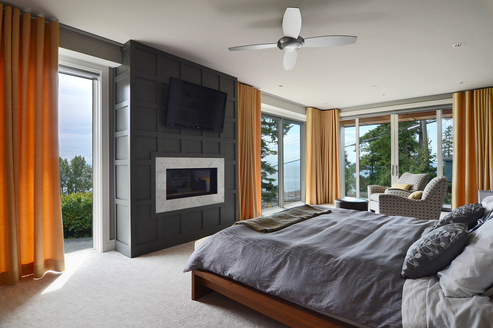 Großes Modernes Hauptschlafzimmer mit grauer Wandfarbe, Teppichboden, Kamin, Kaminumrandung aus Holz und grauem Boden in Vancouver