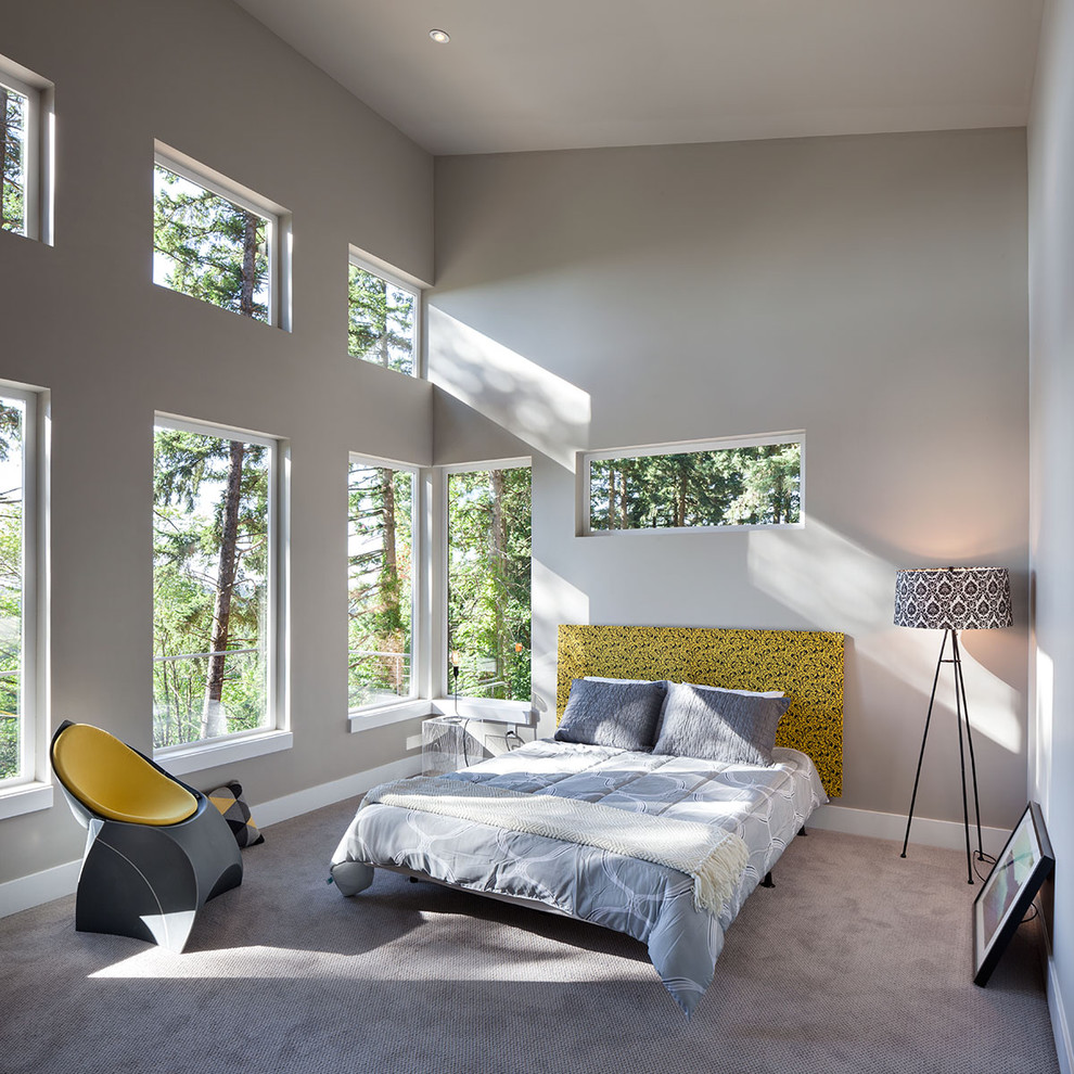 Cette image montre une grande chambre grise et jaune design avec un mur gris, aucune cheminée et un sol gris.
