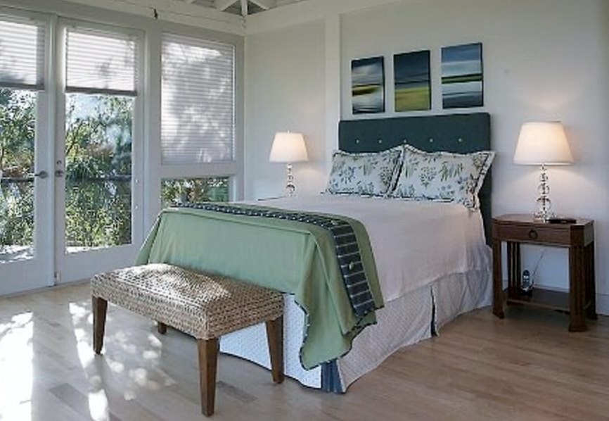 Inspiration for a medium sized nautical master bedroom in Charleston with white walls and light hardwood flooring.