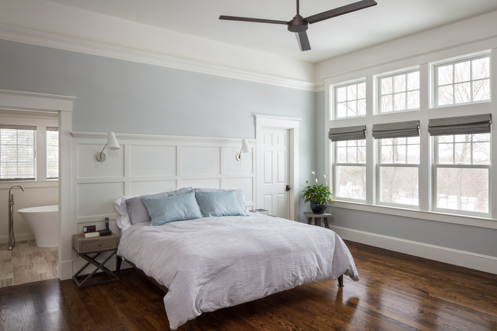 Modelo de dormitorio principal clásico renovado con paredes azules y suelo de madera oscura
