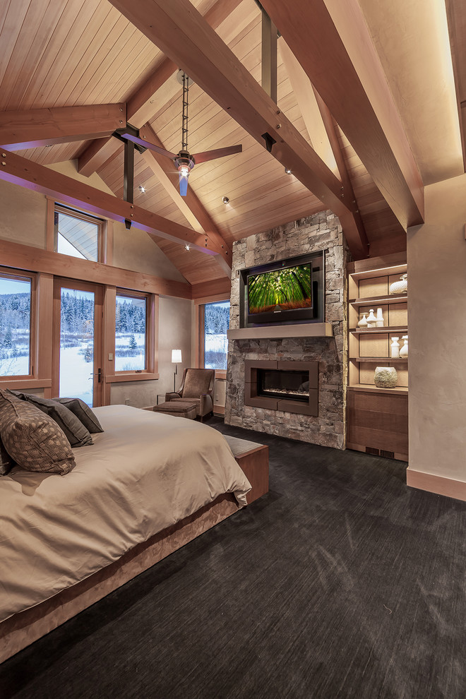 Photo of a large modern master bedroom in Denver with beige walls, carpet, a standard fireplace and a stone fireplace surround.
