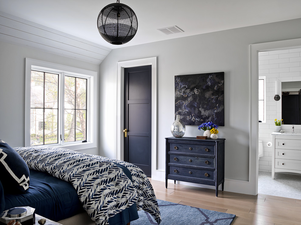 Immagine di una camera da letto country con pareti grigie e pavimento marrone