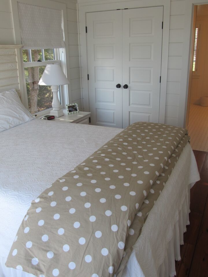 This is an example of a small traditional guest bedroom in Portland Maine with white walls, medium hardwood flooring and no fireplace.