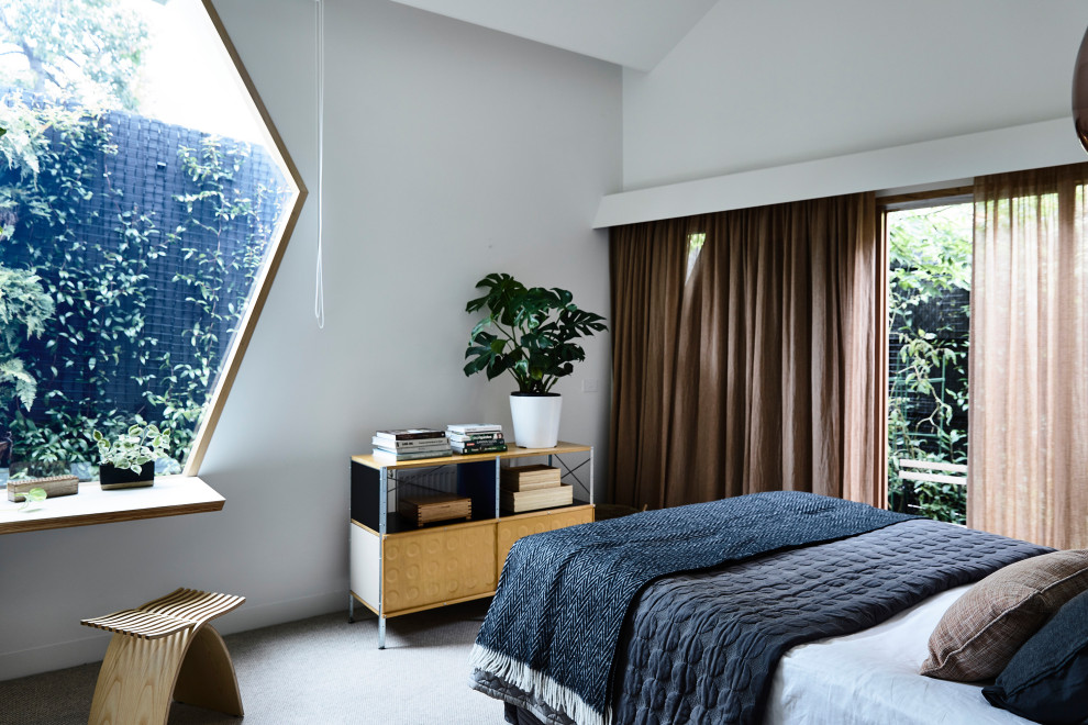 Imagen de dormitorio principal contemporáneo pequeño con paredes blancas, moqueta y suelo beige