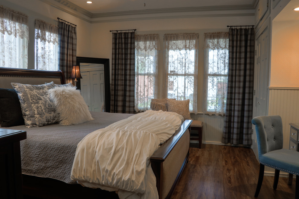 Cette photo montre une petite chambre parentale éclectique avec un mur beige, parquet foncé et un sol marron.
