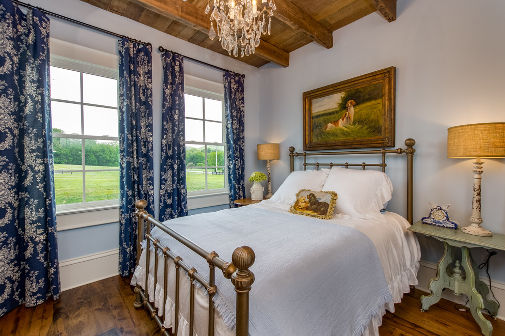 Rural bedroom in Nashville with blue walls, medium hardwood flooring and brown floors.