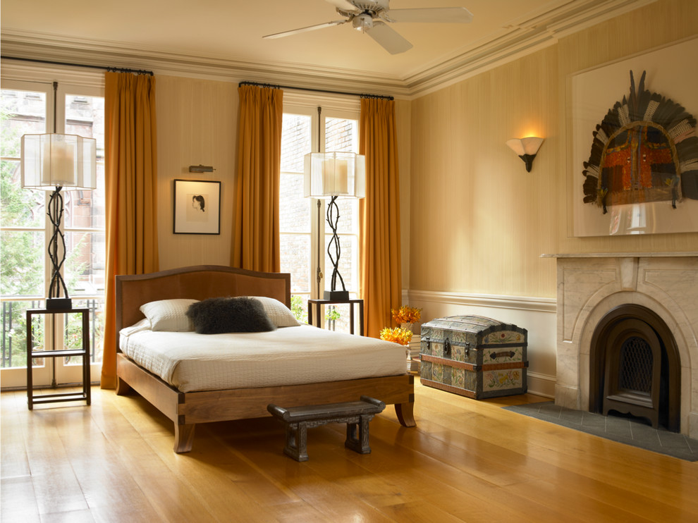 На фото: большая хозяйская спальня в стиле неоклассика (современная классика) с бежевыми стенами, паркетным полом среднего тона, стандартным камином, фасадом камина из камня и желтым полом с