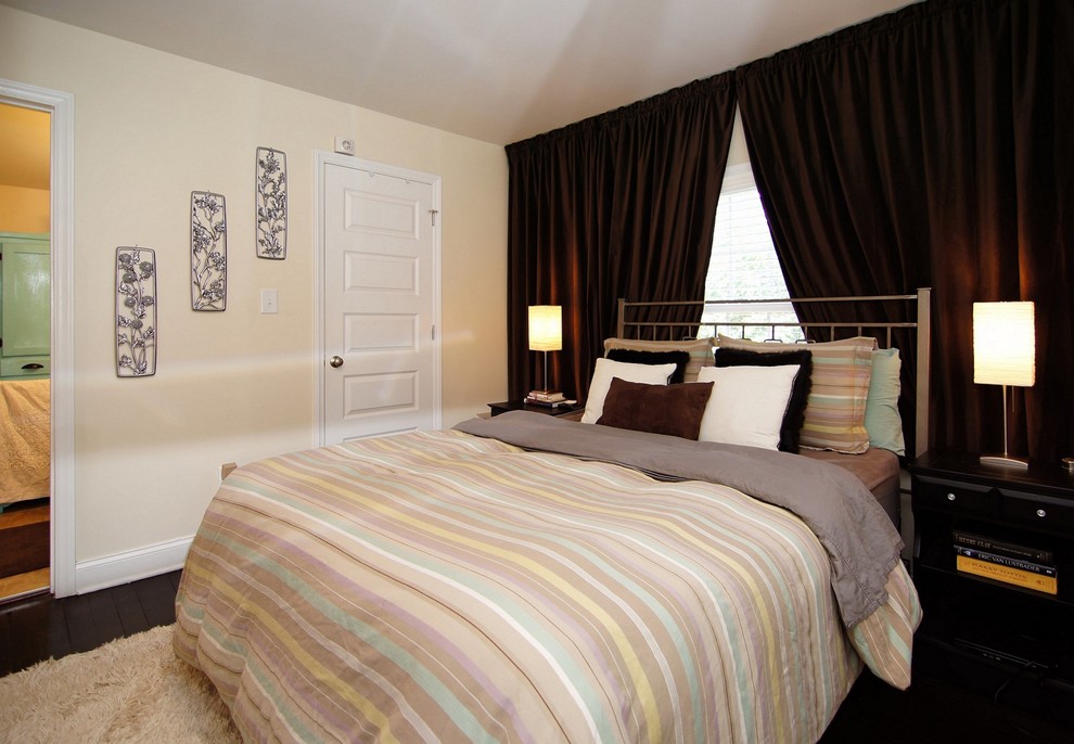 Foto di una piccola camera matrimoniale design con parquet scuro, pavimento marrone e pareti beige