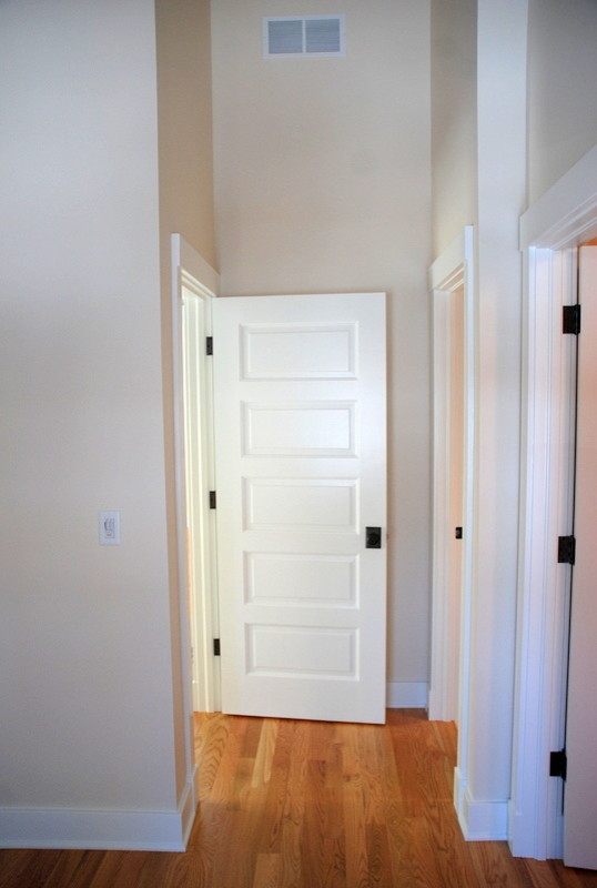 Cette photo montre une chambre parentale chic de taille moyenne avec un mur blanc et un sol en bois brun.