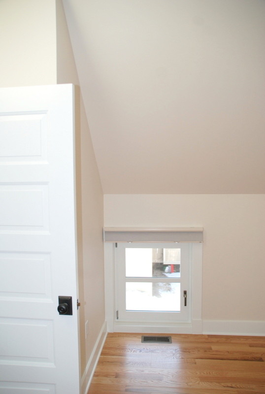 Cette photo montre une chambre d'amis chic de taille moyenne avec un mur blanc et un sol en bois brun.