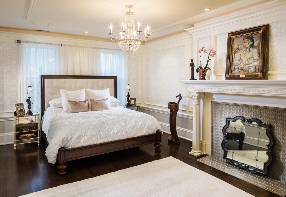 Стильный дизайн: хозяйская спальня в классическом стиле с бежевыми стенами, темным паркетным полом, стандартным камином и фасадом камина из плитки - последний тренд