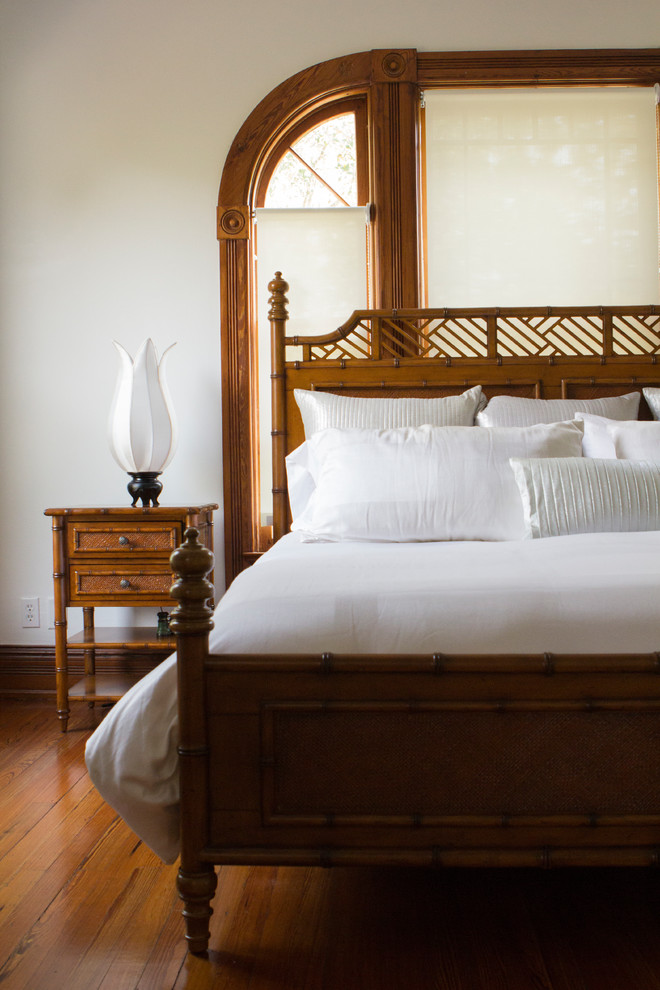Immagine di una camera matrimoniale chic di medie dimensioni con pareti bianche, pavimento in legno massello medio e pavimento marrone