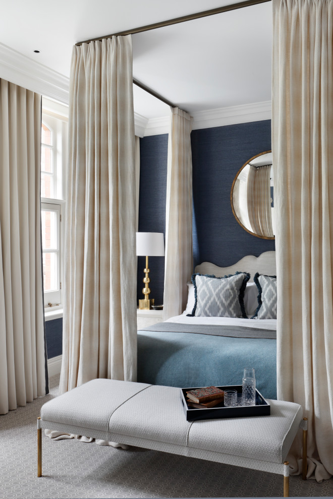 This is an example of a large classic master bedroom in London with blue walls, carpet and grey floors.