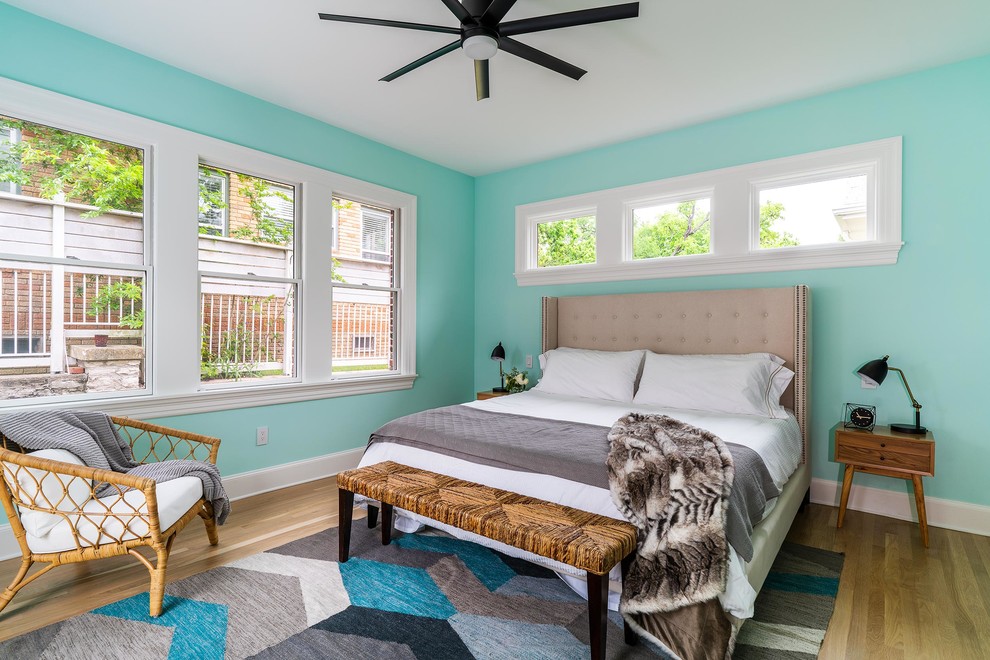 Ejemplo de dormitorio principal marinero de tamaño medio con paredes azules, suelo de madera en tonos medios y suelo marrón