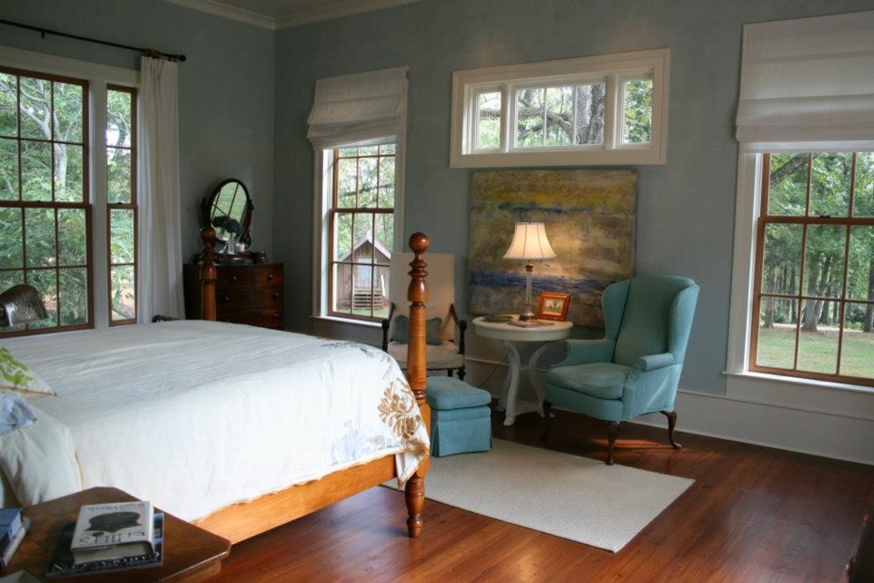 Foto de habitación de invitados de tamaño medio con paredes azules y suelo de madera en tonos medios