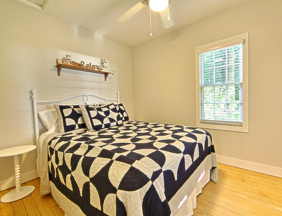 Foto de habitación de invitados marinera pequeña sin chimenea con paredes grises y suelo de madera clara