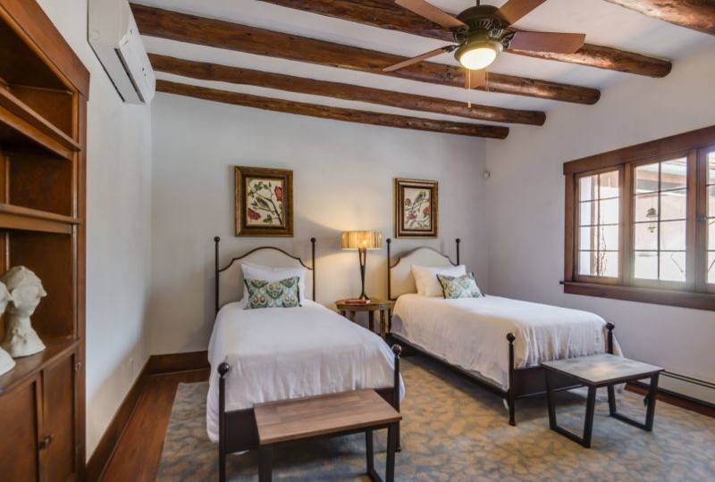 Mittelgroßes Mediterranes Gästezimmer ohne Kamin mit weißer Wandfarbe und braunem Holzboden in Albuquerque
