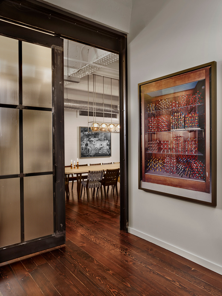 Ejemplo de habitación de invitados urbana de tamaño medio con paredes blancas y suelo de madera en tonos medios