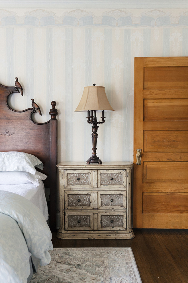 他の地域にある中くらいなヴィクトリアン調のおしゃれな主寝室 (青い壁、ラミネートの床、茶色い床)
