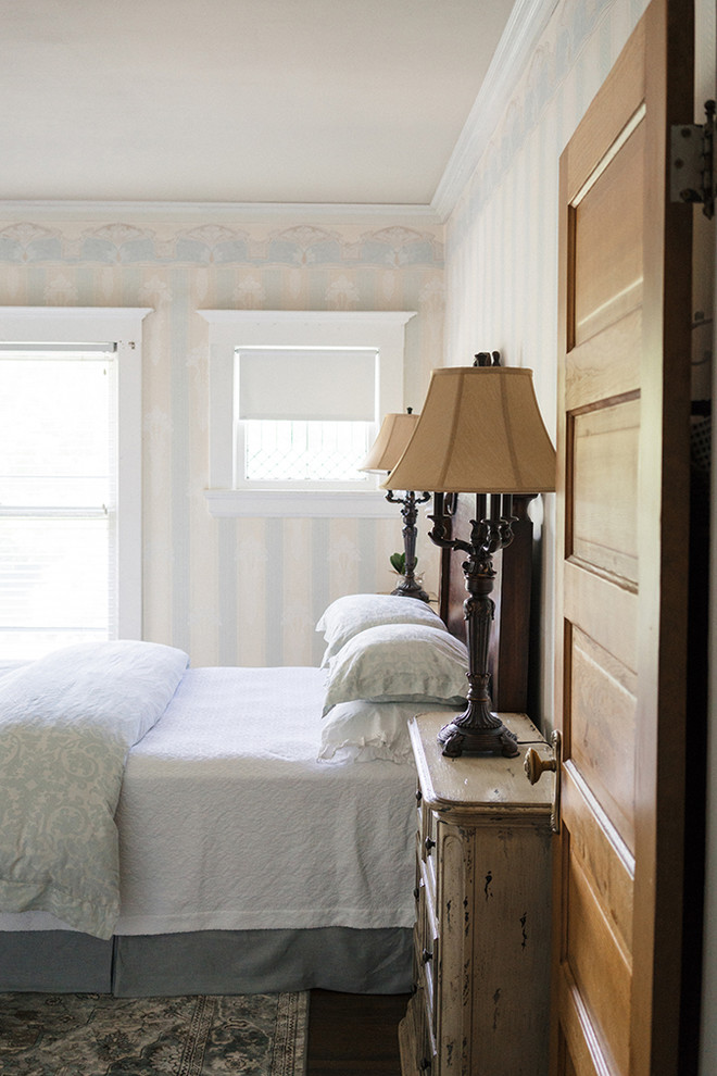 他の地域にある中くらいなヴィクトリアン調のおしゃれな主寝室 (青い壁、ラミネートの床、茶色い床) のインテリア