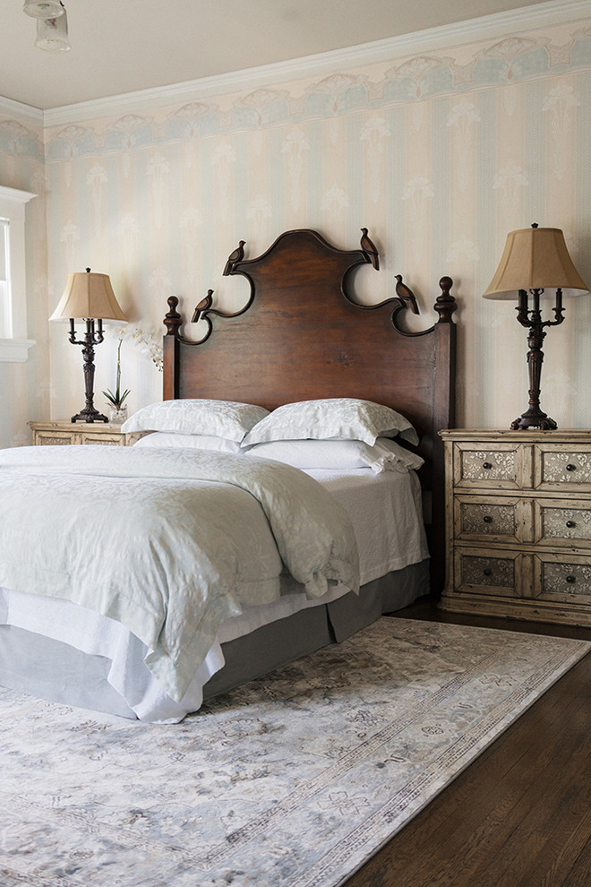 Modelo de dormitorio principal tradicional de tamaño medio con paredes azules, suelo laminado y suelo marrón