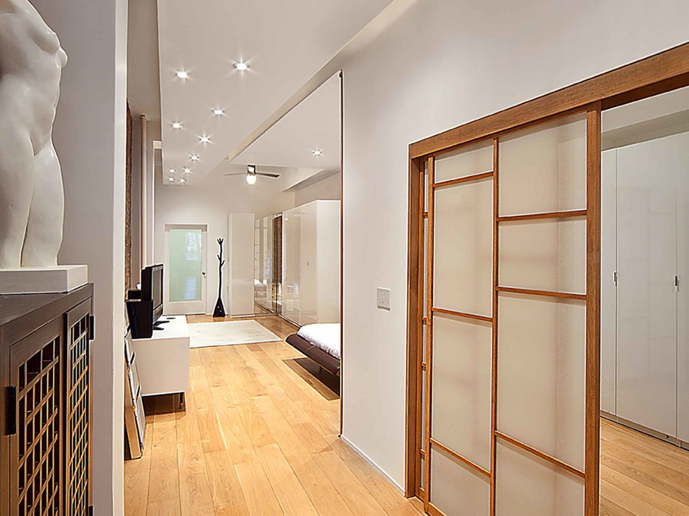 Idées déco pour une grande chambre parentale contemporaine avec un mur blanc et un sol en bois brun.