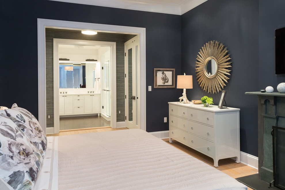 На фото: хозяйская спальня в стиле неоклассика (современная классика) с синими стенами, светлым паркетным полом и стандартным камином с