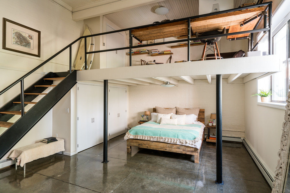 Diseño de dormitorio principal bohemio grande sin chimenea con paredes blancas, suelo de cemento y suelo gris