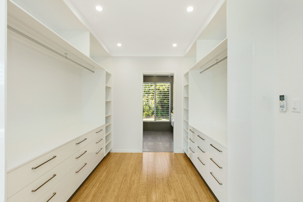 Inspiration pour une chambre parentale minimaliste de taille moyenne avec un mur blanc et parquet en bambou.